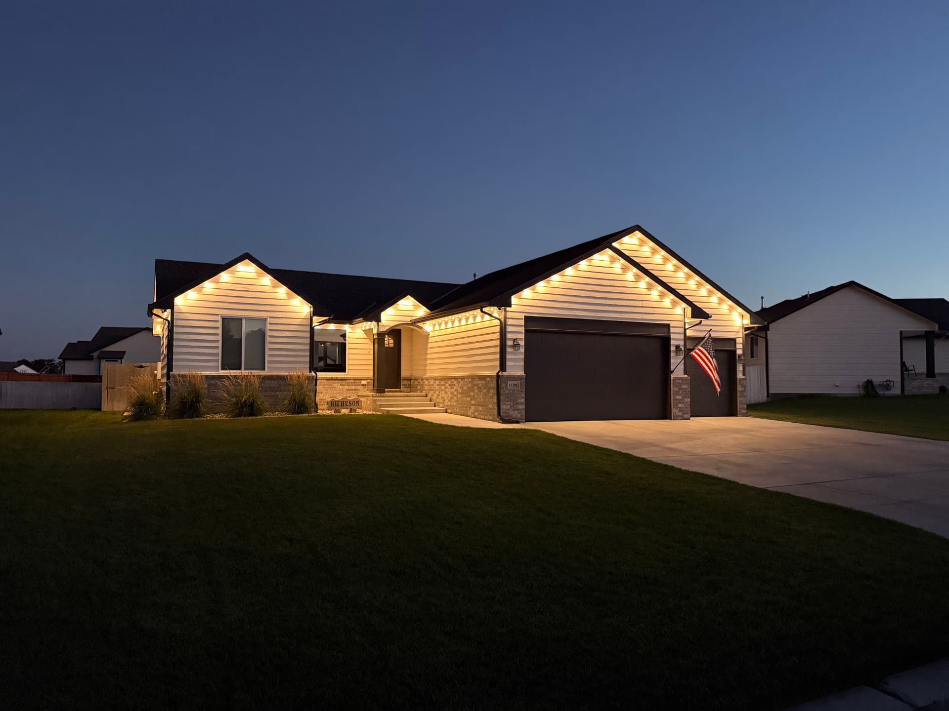 Ranch home with warm white permanent LED lighting along the peaks and roofline at dusk