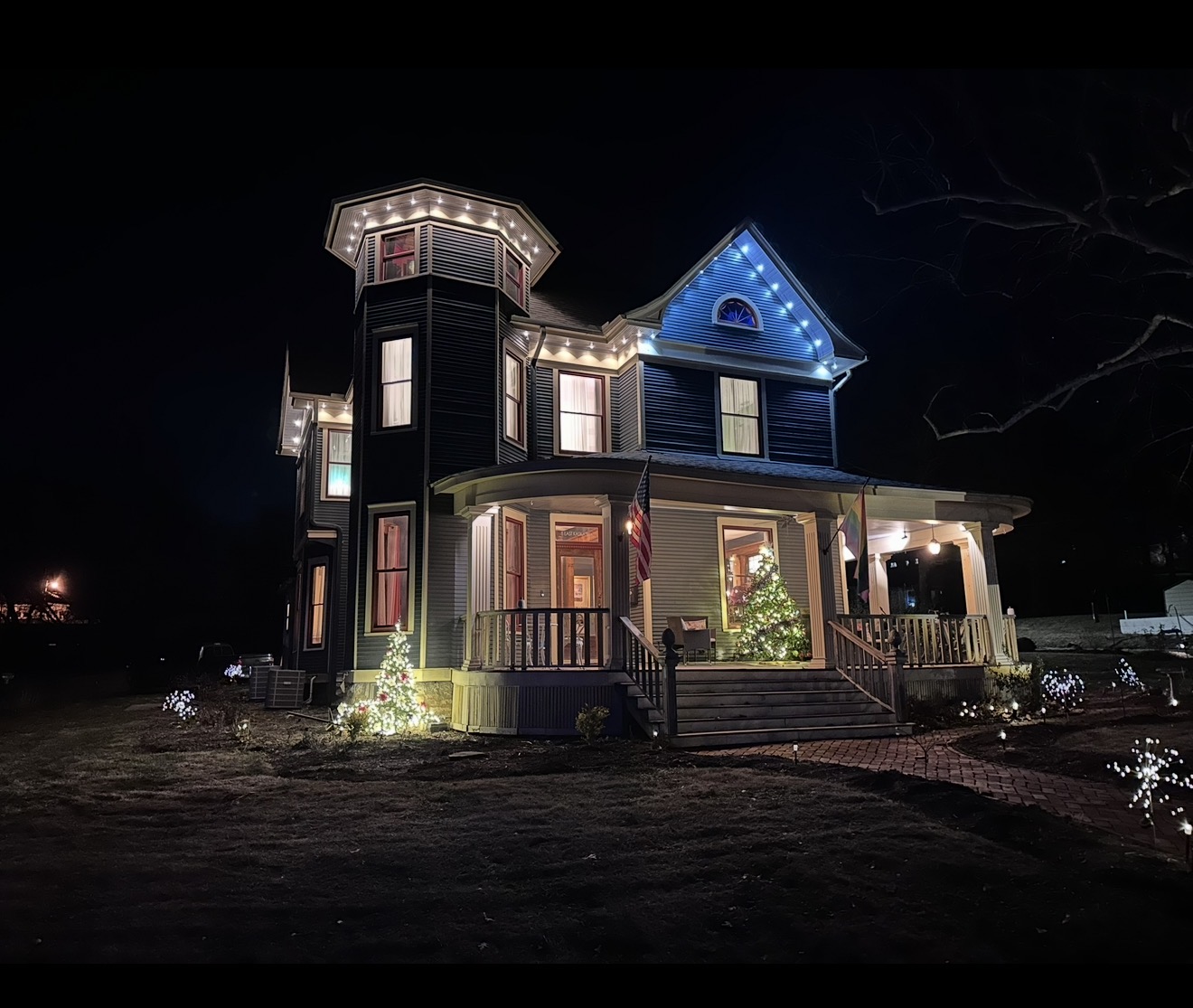 Victorian two-story home with warm white and blue permanent LED accent lighting